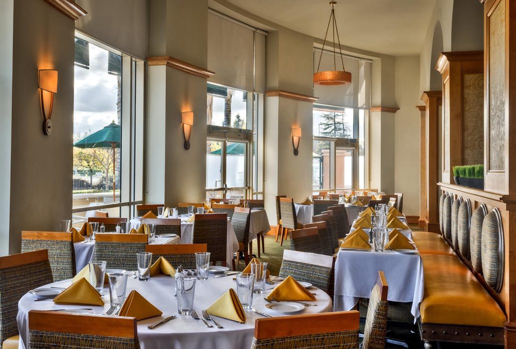 La Fontana Restaurant indoor dining area at Hilton Santa Clara with natural lighting and tables set for service near Levi’s Stadium, Californias Great America, and the Santa Clara Convention Center