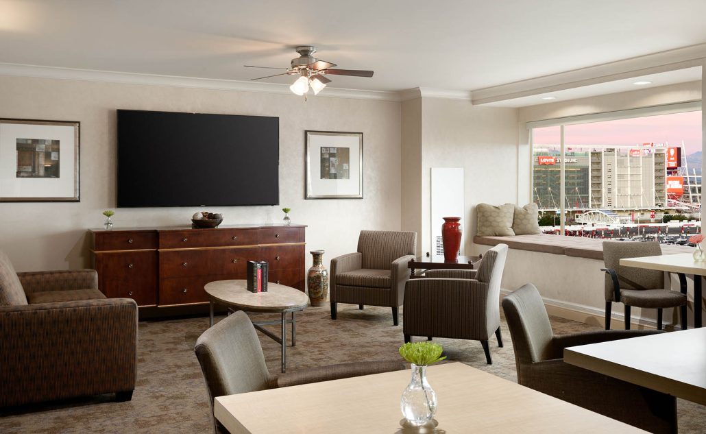 Concierge Meeting Room at Hilton Santa Clara with a casual lounge-style setup, armchairs, meeting table, flat-screen TV, and natural window light