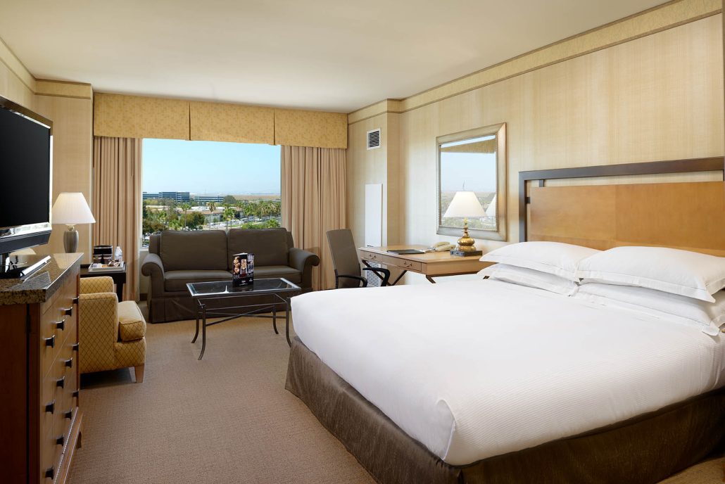 Hilton Santa Clara guest room with king bed and sofa bed, shown in Santa Clara hotel room tours for up to 4 guests.