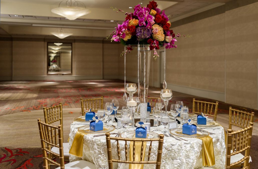 Elegant ballroom setup with floral centerpiece and formal place settings at Hilton Santa Clara, highlighting Santa Clara catering for events.