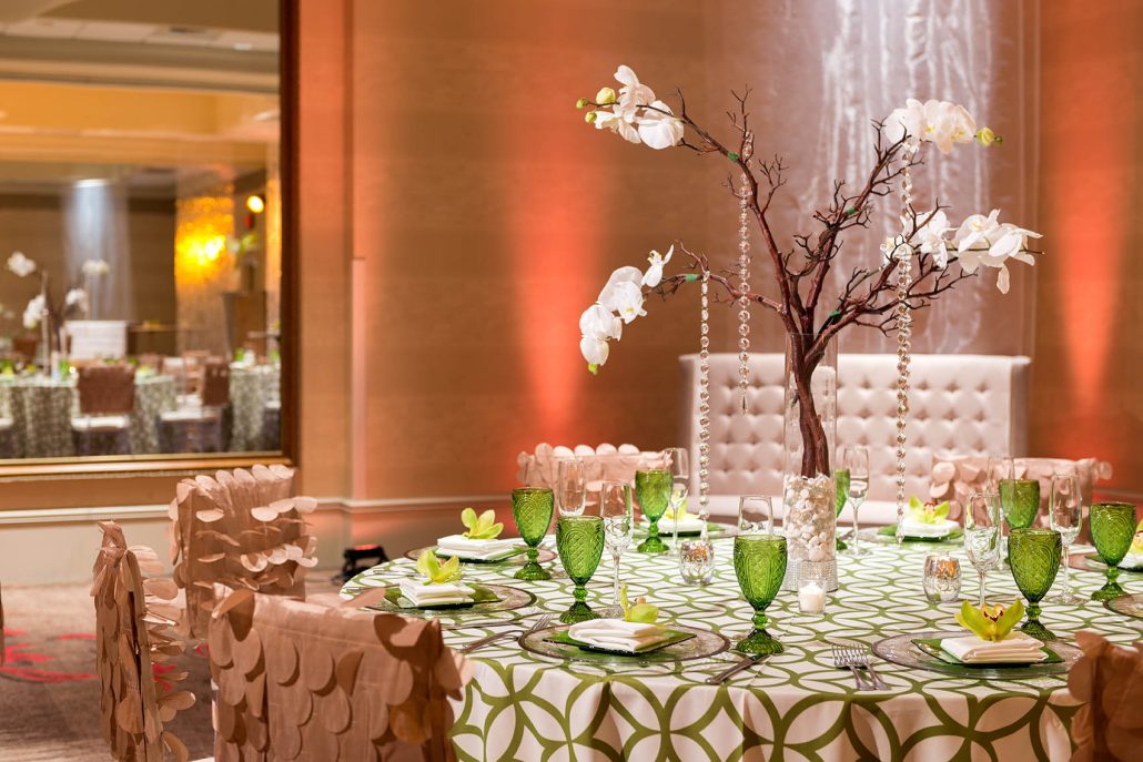 Vibrant banquet setup with green glassware and floral centerpiece at Hilton Santa Clara, showcasing Santa Clara catering for events.