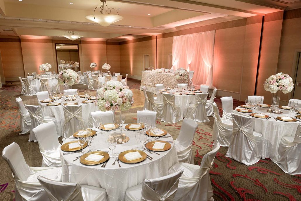 Ballroom wedding reception setup with white linens and floral centerpieces at Hilton Santa Clara, showcasing Santa Clara catering for events.
