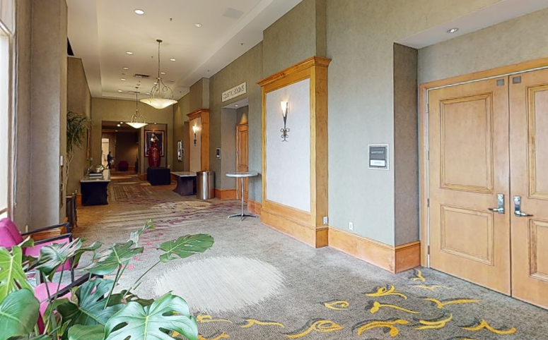 Pre-Function Area at Hilton Santa Clara featuring open carpeted space with decorative lighting and access to adjacent meeting rooms; ideal for registration, breaks, or receptions
